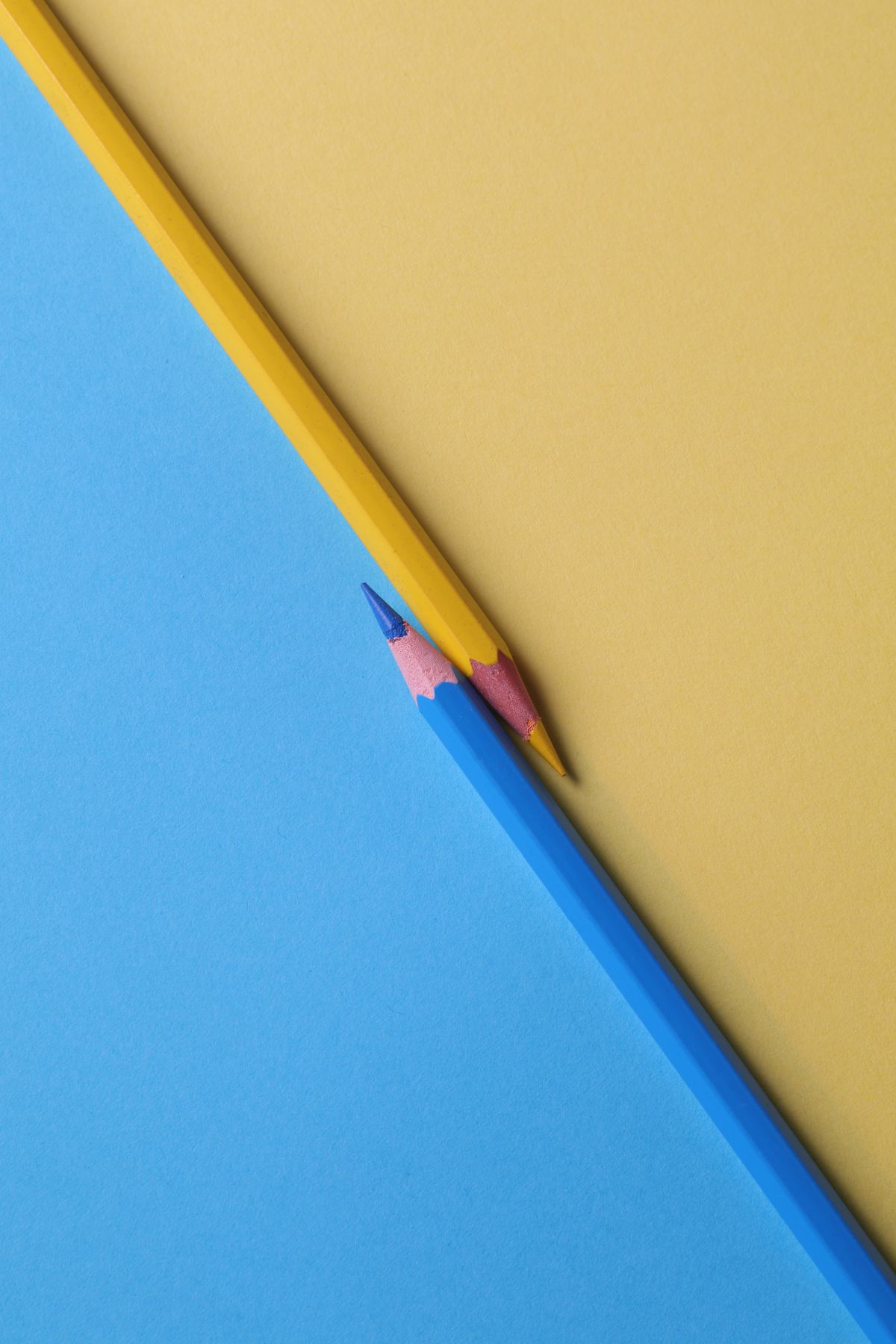 Lápices azul y amarillo sobre papel